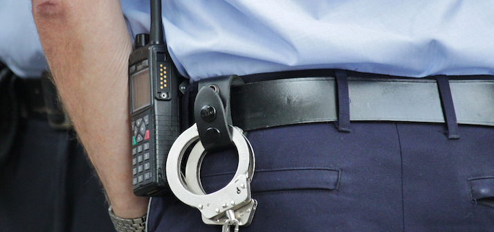 Police officer with handcuffs and radio strapped to belt