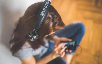 Girl with headphone using mobile phone