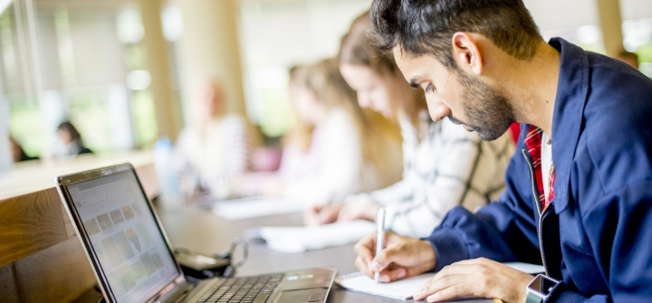 Student writing notes in the George Green Library