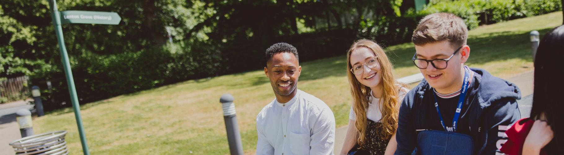 University students sit on a wall at an open day
