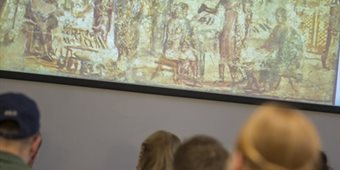 Students in a seminar room look at a slide of artwork.