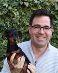 Headshot of Gwilym Dodd holding a small dog