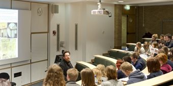 A lecture is delivered in the arts centre lecture theatre to students sitting in rows