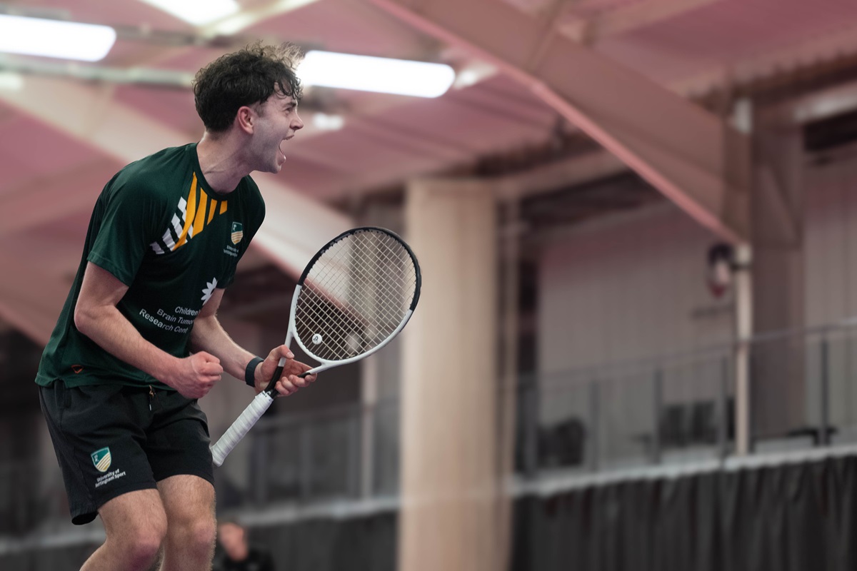Male tennis player clenches fist in celebration