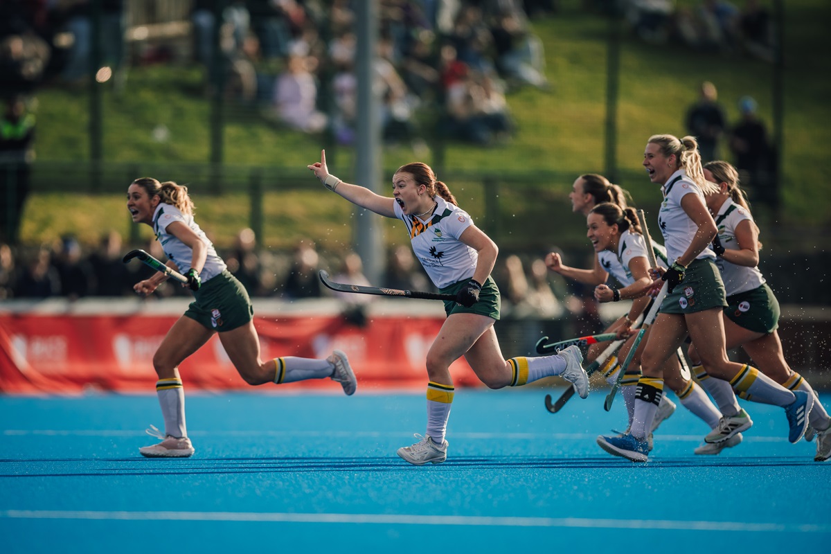 Women's hockey raise arms in celebration
