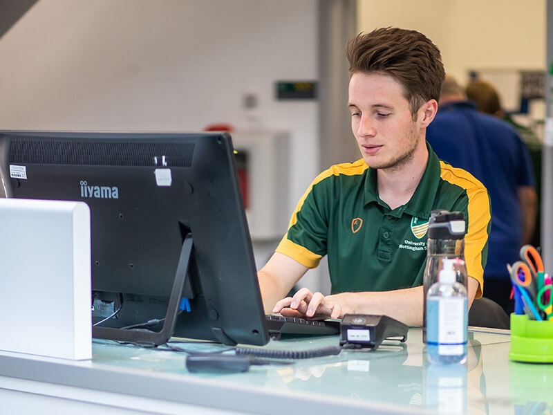 A receptionist working on a computer at David Ross Sports Village