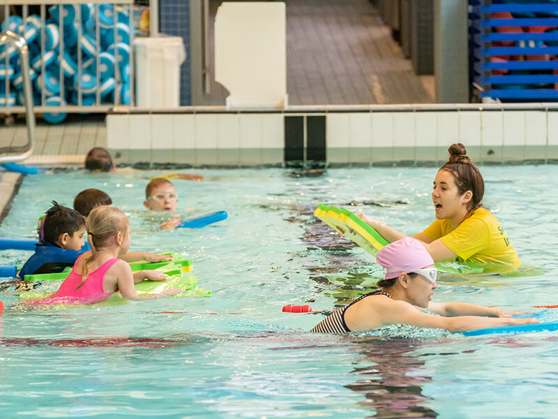 Swim instructor taking a swim school lesson