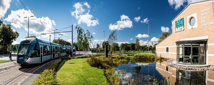 External view of Lakeside Arts building with a tram driving past