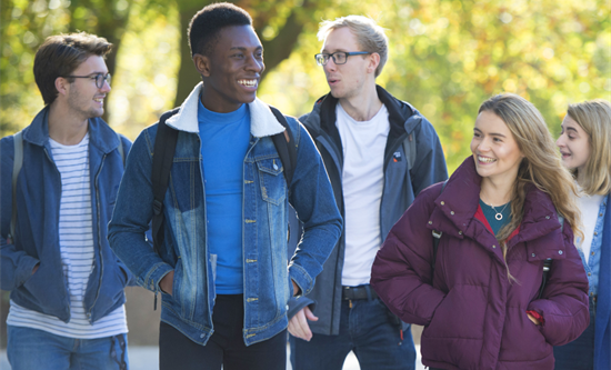 Group of students walking outside talking and smiling