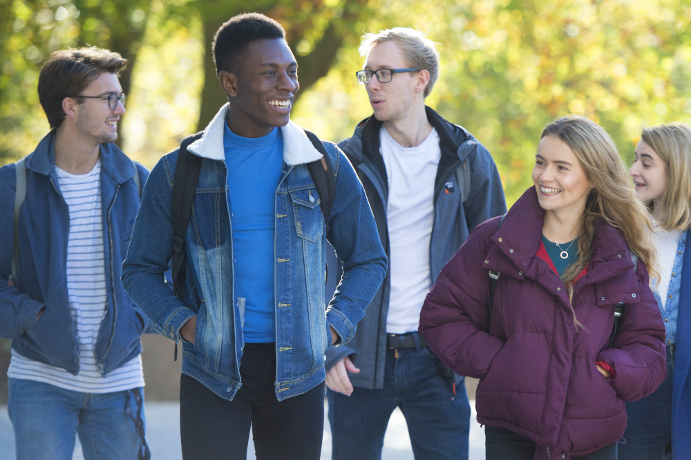 Mixed group of students walking and talking outdoors