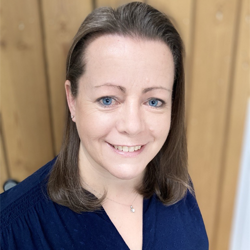 Photo of Helen Day. Helen has shoulder length brown hair and is wearing a blue blouse and a necklace.