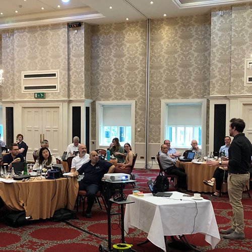 People sat at tables in a function room for a presentation during an Executive Education delivered programme.