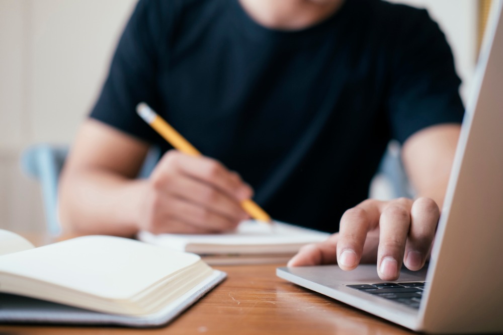 A close up of a man hands using a laptop