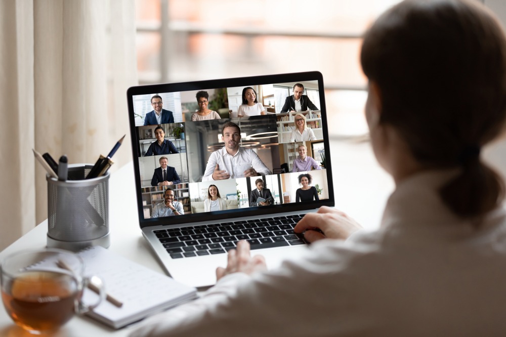 A woman on a laptop conversing with colleagues through the web