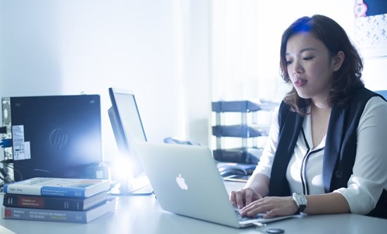 A woman using a laptop in an office
