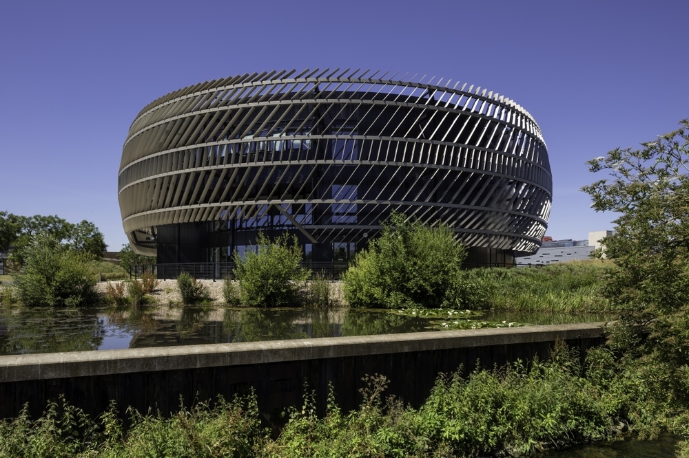 Ingenuity Centre on Jubilee Campus. A walkway in the foreground and trees in the background. The Ingenuity Centre building looks like a tyre on its side.