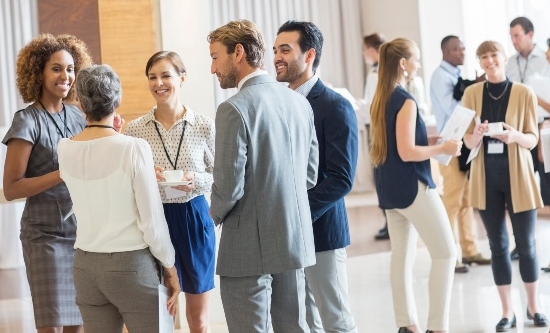 Group of business standing in a room networking