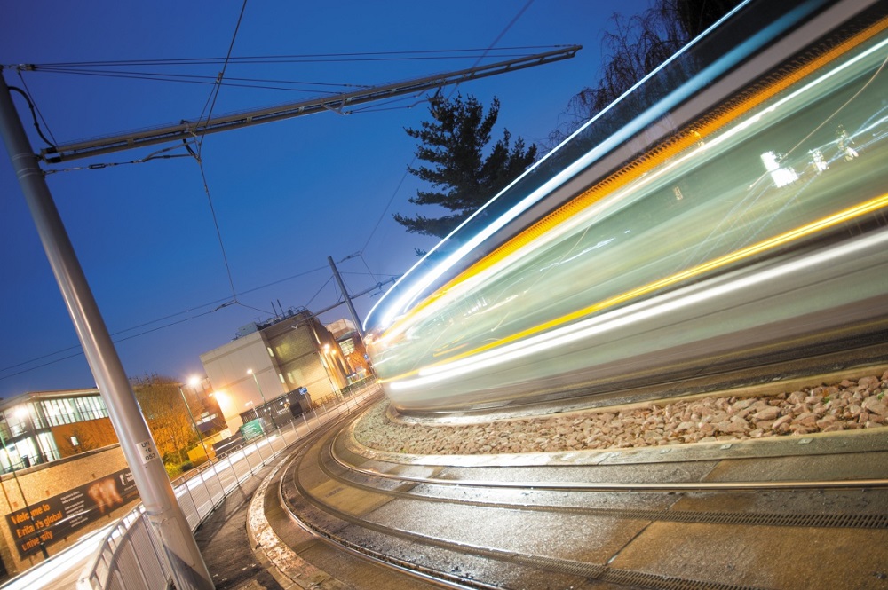 A tram travelling through University Park at night