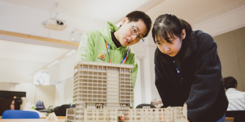 Two students examining models together