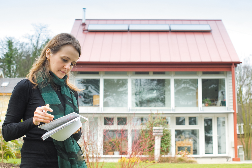 A student taking notes in front of one of the Creative Energy Homes on University Park Campus