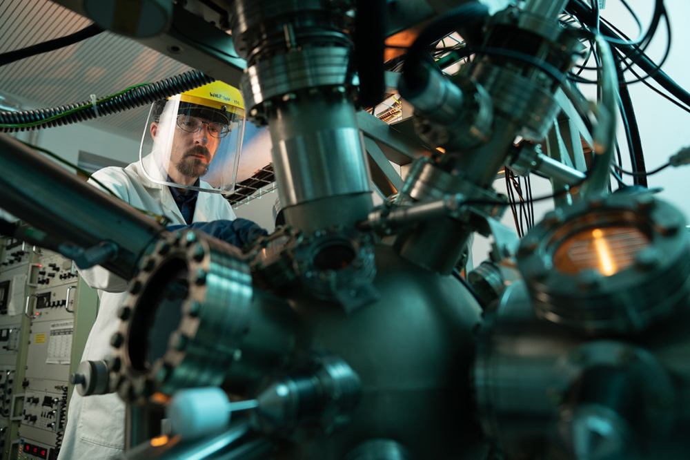 Technician working with heavy machinery, wearing a hard hat and visor
