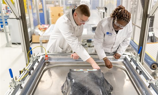 Two people examining a composite structure in a lab