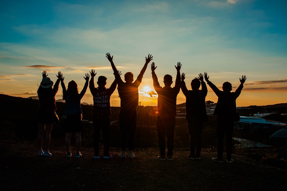 Group of people watching the sunset on top of a hill