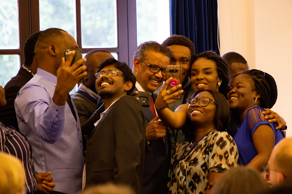 A group of people smiling and taking photos with each other
