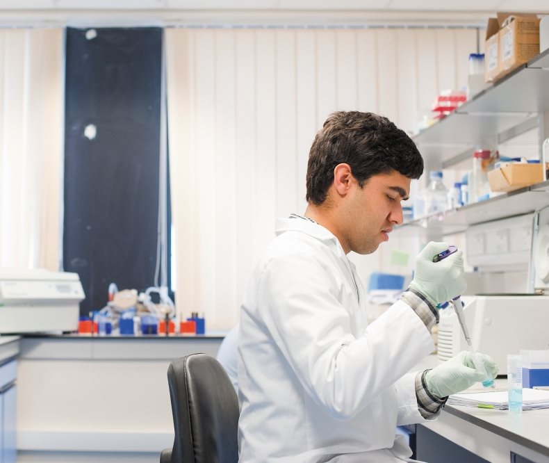Student pipetting in analytical laboratory