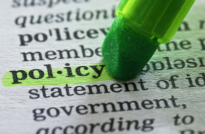 Policy typed on paper being highlighted by pen