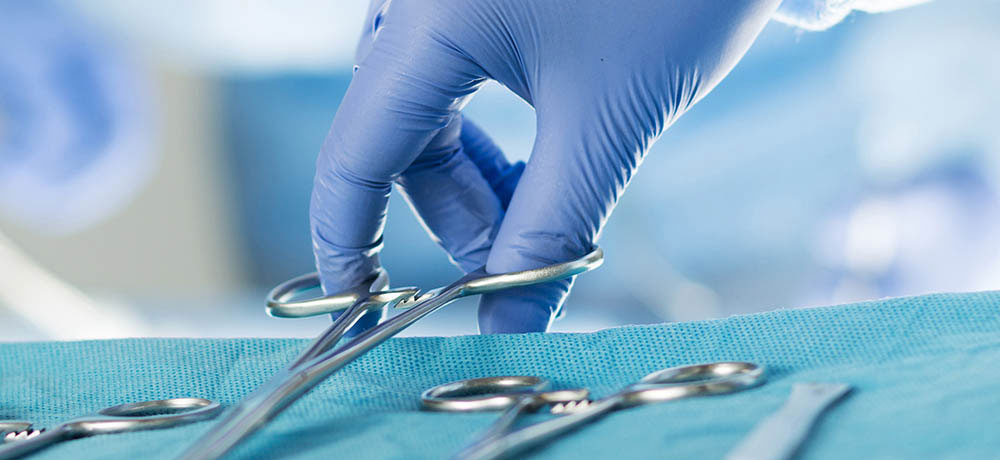 Student vet picking up scissors